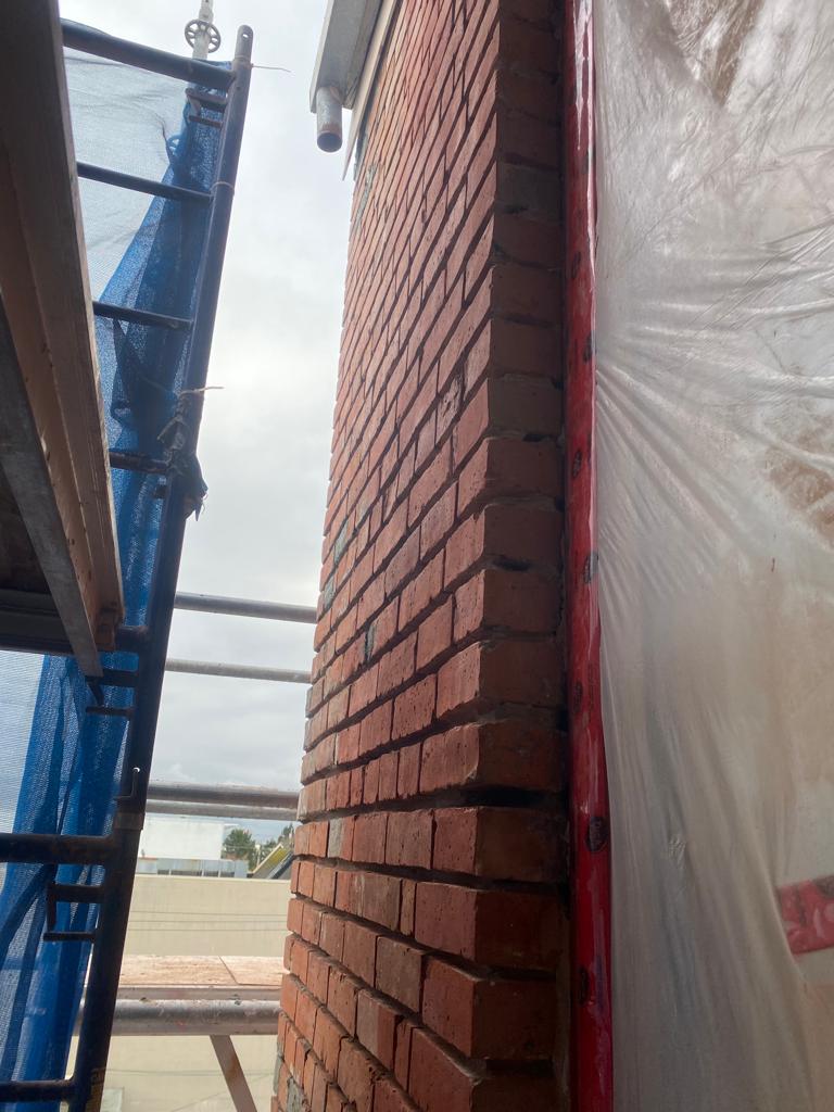 Restored brick corner detail with scaffold — The Keefer