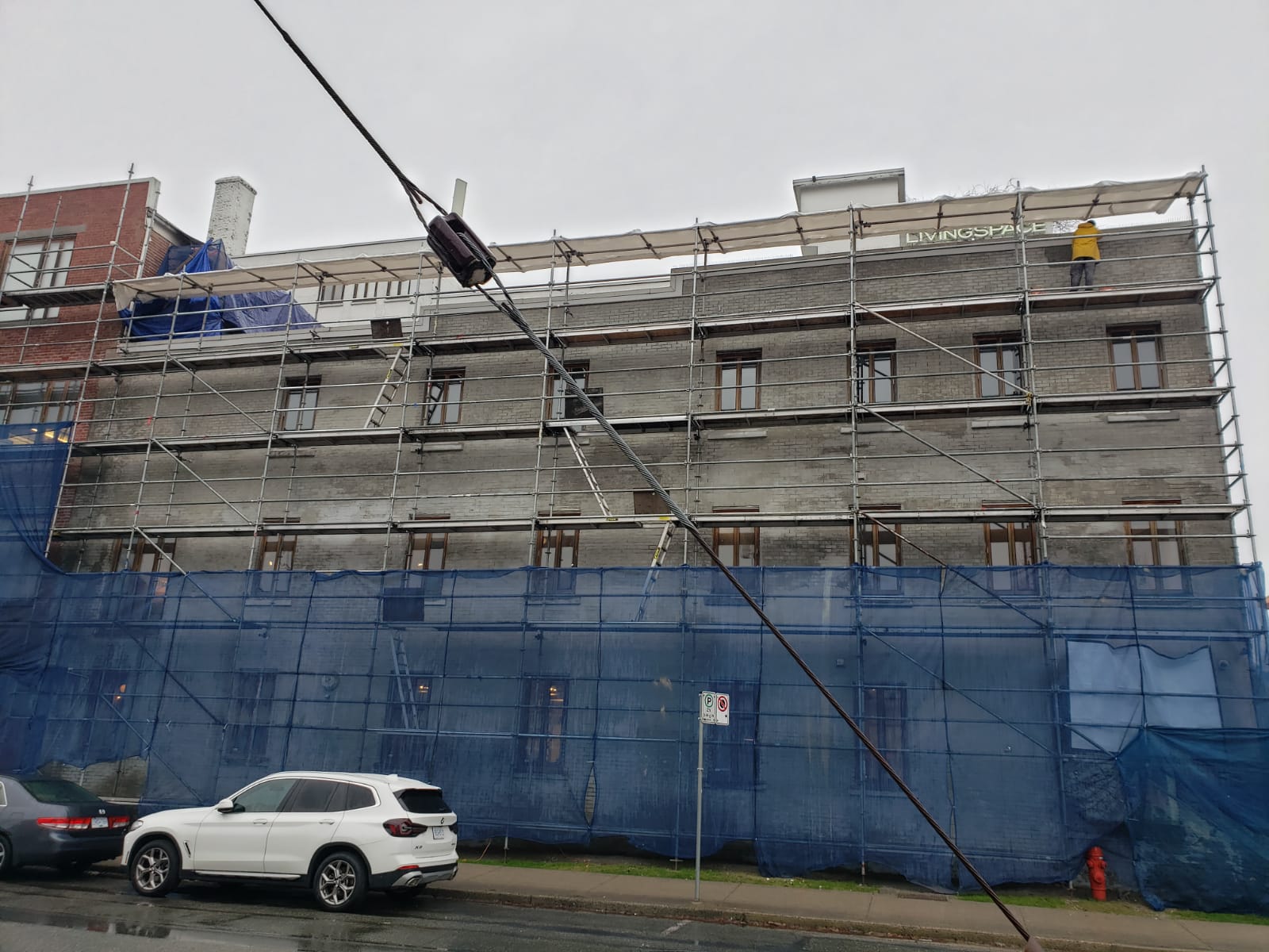 Full scaffold and debris netting during restoration — Living Spaces