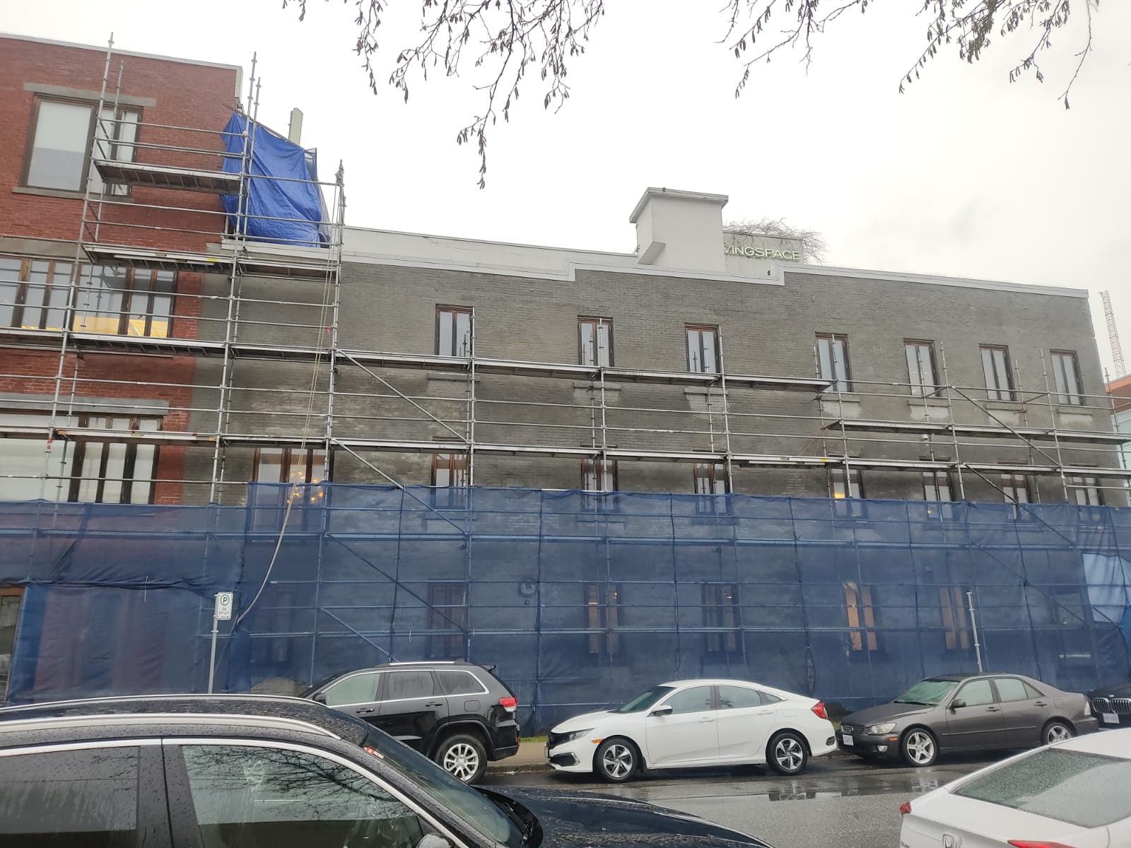 Street view of scaffolded heritage building — Living Spaces