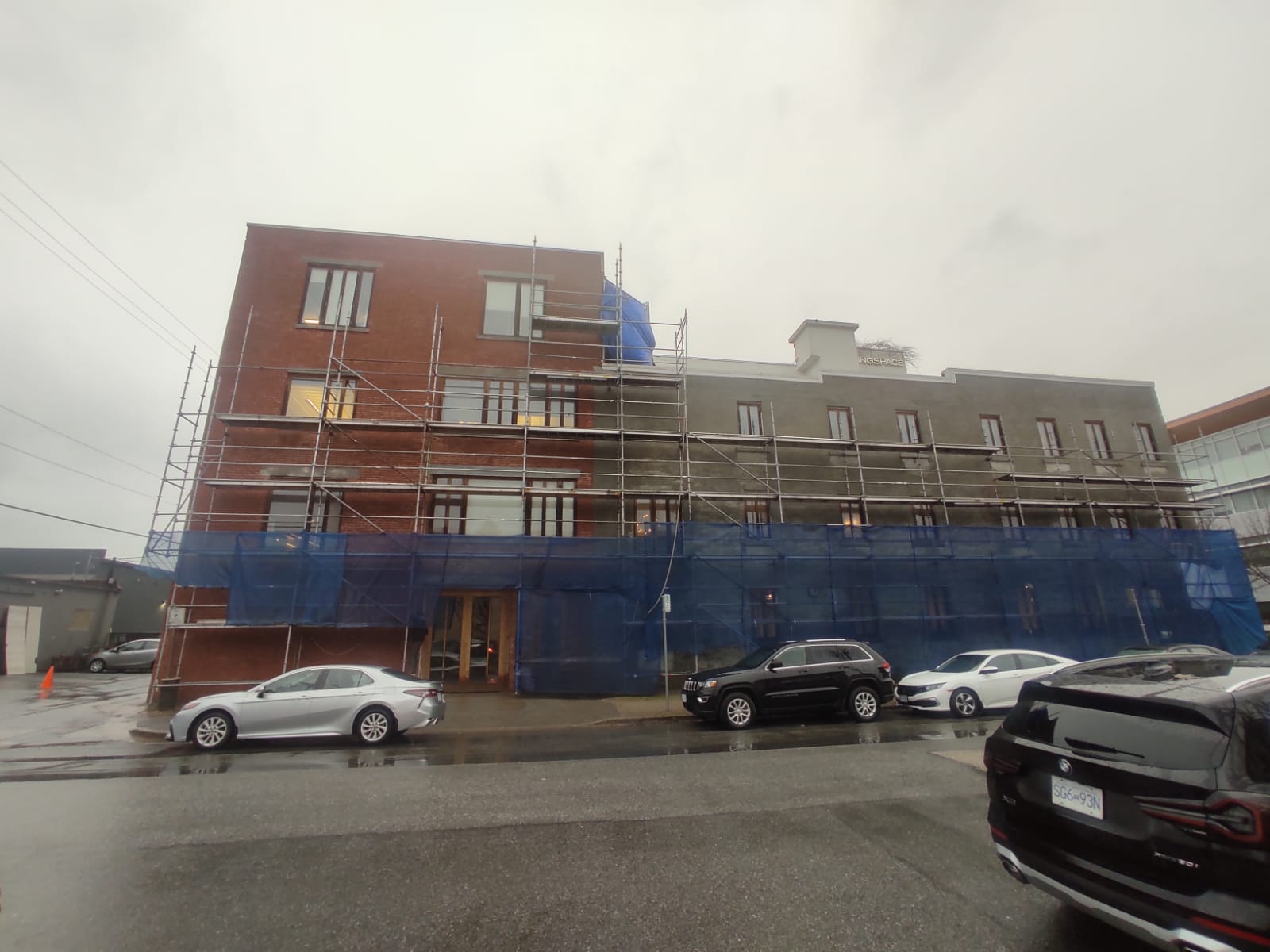 Wide exterior view during envelope restoration — Living Spaces