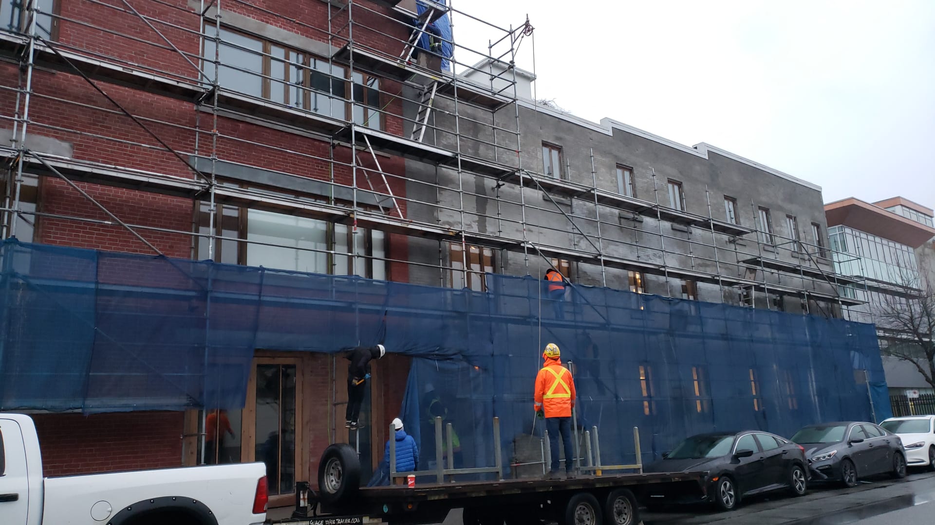 Crew delivering materials by flatbed at street level — Living Spaces