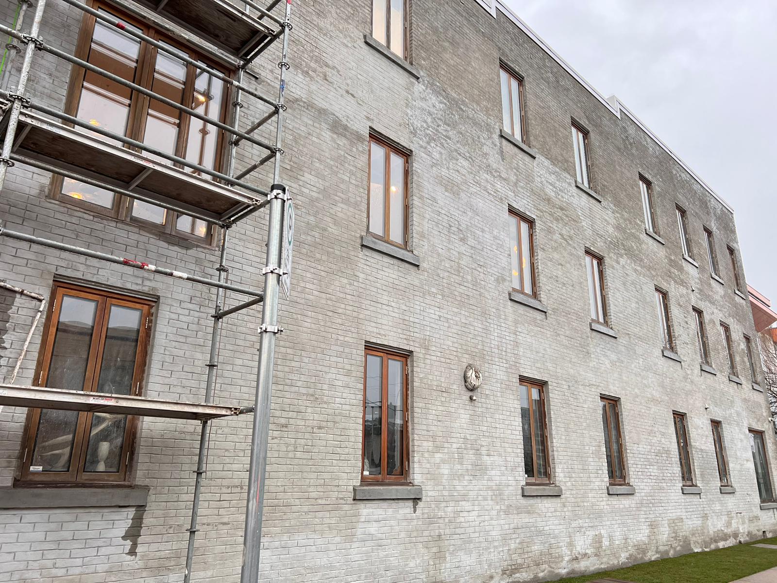 Painted heritage brick facade prior to restoration — Living Spaces