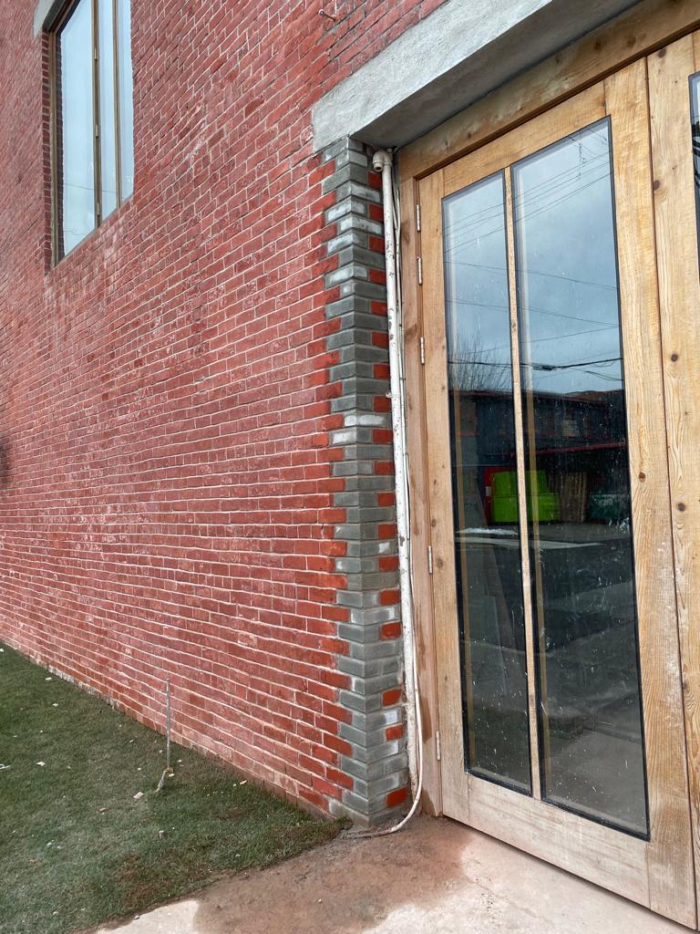 Checkerboard brick corner detail on rooftop addition — Living Spaces