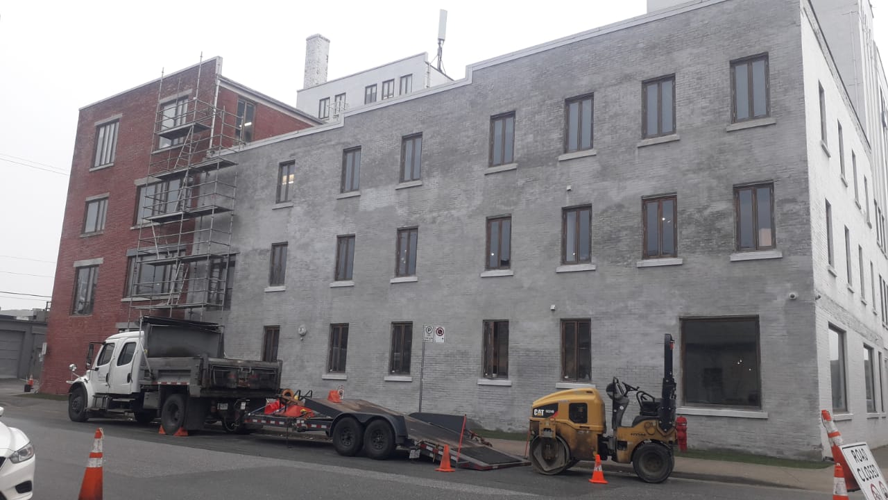 Site equipment staged for envelope restoration — Living Spaces