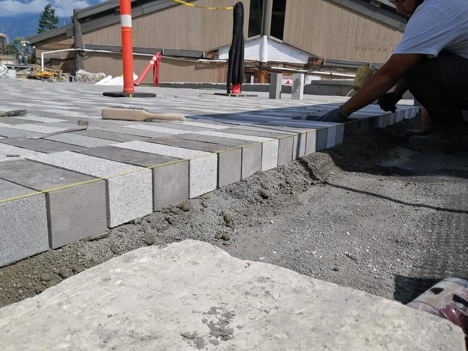 Installer setting paver edge course — Sewell's Landing