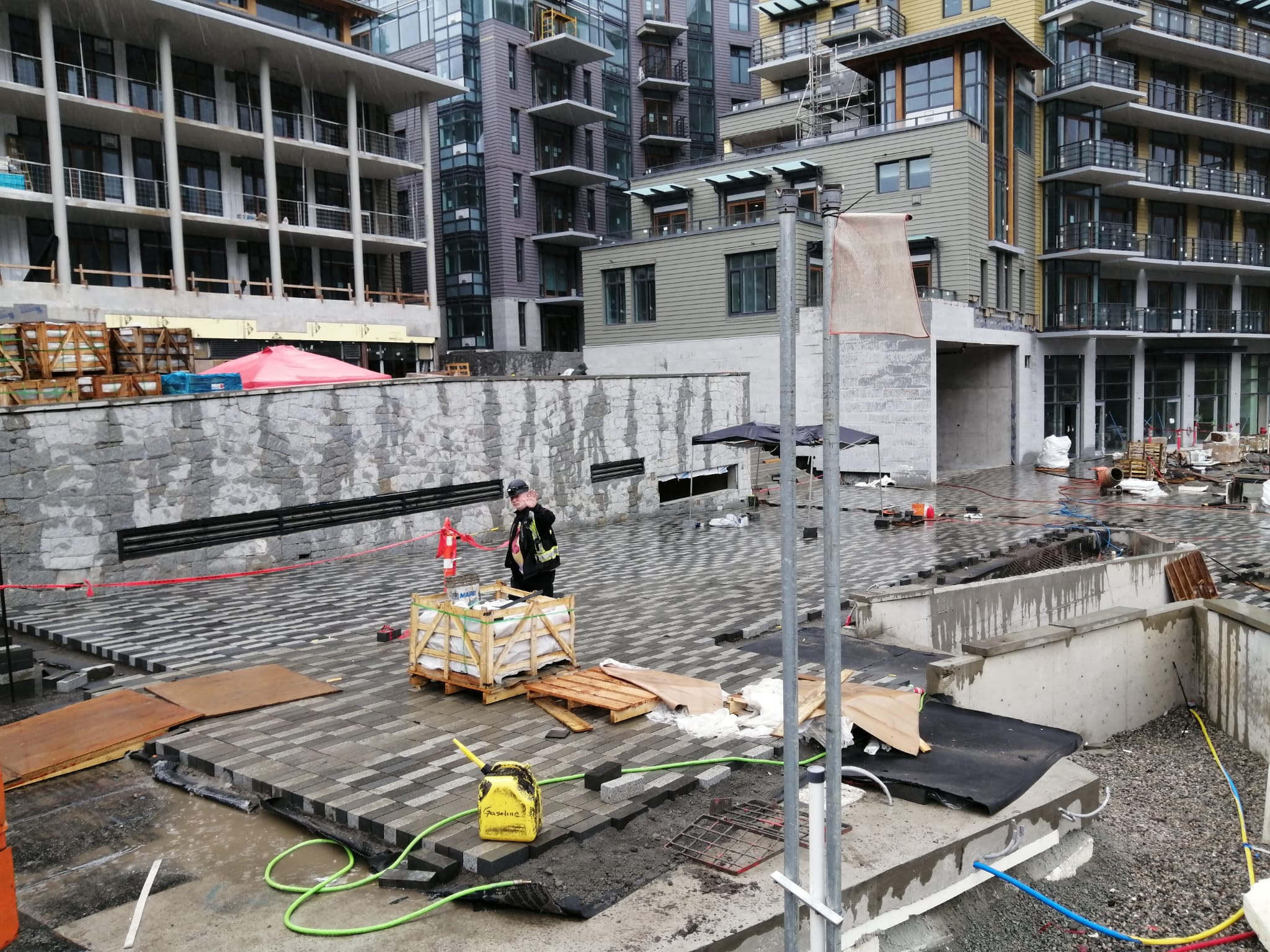 Site crew coordinating paver plaza build-out — Sewell's Landing