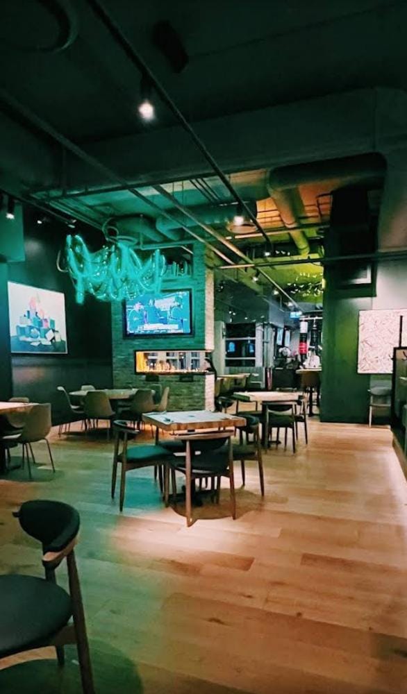 Finished lounge seating beneath feature lighting — Tap & Barrel