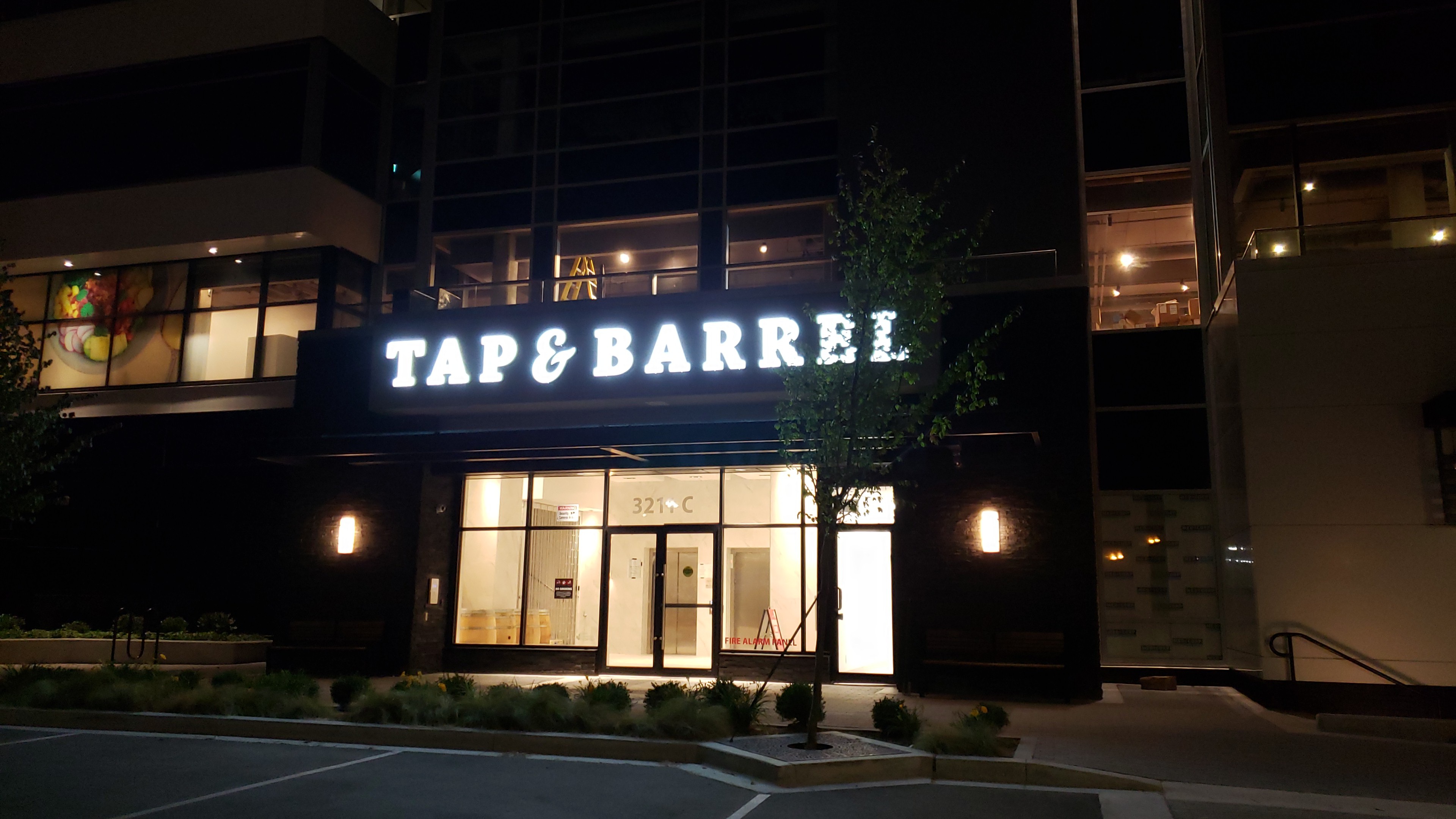 Illuminated Tap & Barrel storefront sign at night — South Surrey
